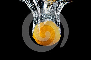 Fresh Orange fruit under water with reflection. Healthy cytrus lemon vegetable splashing into clear water making lemonade.