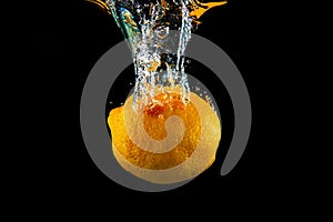 Fresh Orange fruit under water with reflection. Healthy cytrus lemon vegetable splashing into clear water while washing