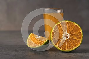 Fresh orange fruits and juice on stone table