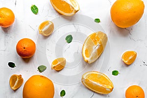 Fresh orange fruits with mint on table background top view pattern