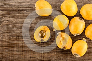 Fresh orange Japanese loquats on brown wood