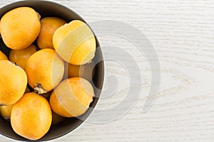 Fresh orange Japanese loquats on grey wood