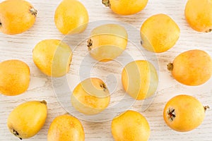 Fresh orange Japanese loquats on grey wood