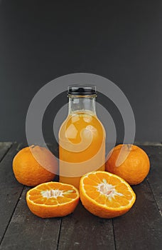 Fresh orange juice and fruit on black table