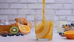 Fresh orange juice poured into the glass for breakfast