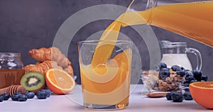 Fresh orange juice poured into the glass for breakfast