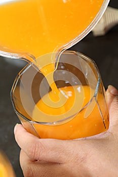 Fresh orange juice pouring from a jug