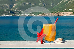 Fresh orange juice on the seaside background.