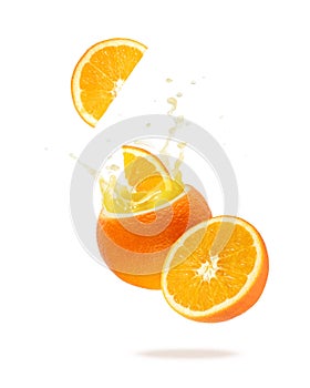 Fresh orange juice splashing from fruit isolated on white background with copy space. Orange slice flying falling into fruit