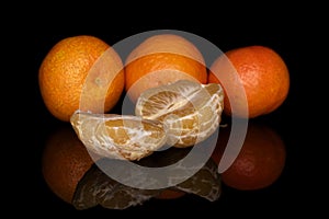 Fresh orange mandarin isolated on black glass