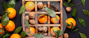 Fresh orange mandarins, tangerine with green leaves in wooden box. Top view