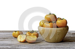 Fresh orange organic ripe Fuyu Persimmons or Persimon fruits Kaki in wooden bowl