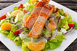 Fresh Orange Salmon salad with honey, tomatoes, onion, mandarin. healthy food concept.