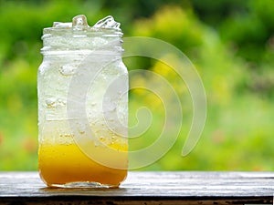 A fresh orange soda drink filled with ice in vintage style gla photo