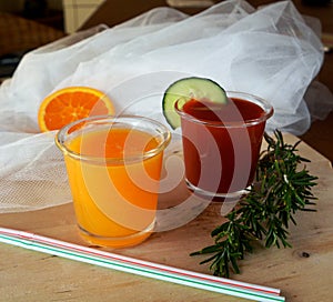 Fresh orange and tomato smoothie on a glass.