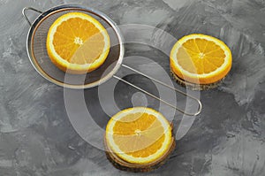 Fresh oranges, cut into slices, lie on a rustic table for making juice