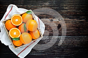 Fresh oranges fruit in wooden basket. Pile of oranges top view