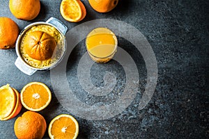 Fresh oranges juicer juice and tropical fruits on concrete board