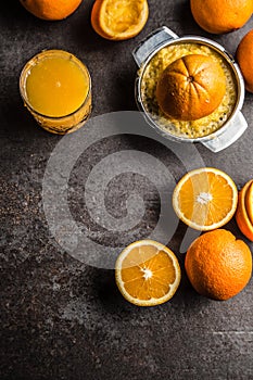 Fresh oranges juicer juice and tropical fruits on concrete board