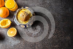 Fresh oranges juicer juice and tropical fruits on concrete board