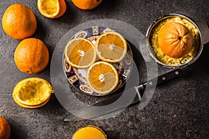 Fresh oranges juicer juice and tropical fruits on concrete board