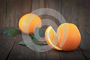 Fresh oranges with leaves on wooden background