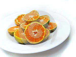 Fresh oranges on the plate isolated on white background