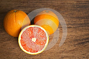 Fresh oranges with slices on wooden background.