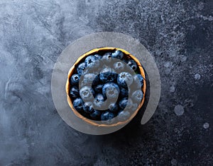 Fresh organic blueberry in mini basket on vintage dark table. Concept of healthy eating. Top view, copy space