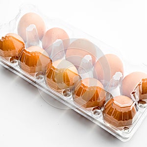 Fresh organic brown eggs in a plastic package, isolated on white background
