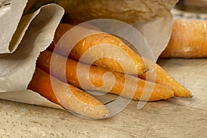 Fresh organic carrots in recyclable paper bag