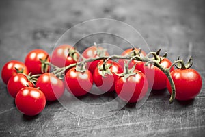 Fresh organic cherry tomatoes bunch closeup on black board