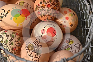 Fresh organic chicken eggs with Easter decoration, in a metal basket