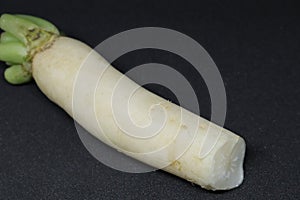 Fresh organic daikon radishes isolated on black background