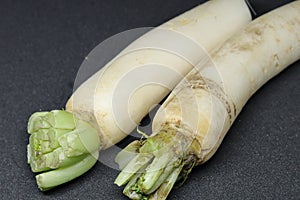 Fresh organic daikon radishes isolated on black background