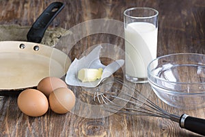 Fresh organic eggs, milk and butter on wooden background