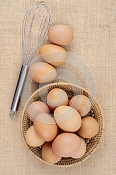 Fresh organic eggs in weave basket on sack