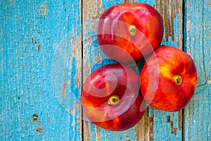 Fresh organic flat nectarines on an old wooden background