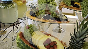 Fresh organic fruits cut into slices stand at  expensive buffet with alcohol