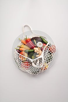 Fresh organic fruits and vegetables in mesh textile bag