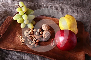Fresh organic fruits on wood Serving tray. Assorted apple, pear, grapes, dried fruits and nuts.