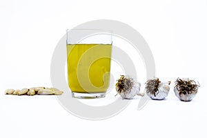 Fresh organic Garlic juice isolated on white along with fresh garlic cloves and garlic bulbs.