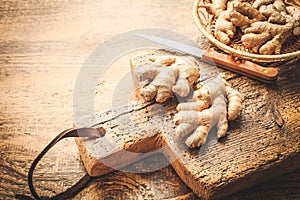 Fresh organic ginger roots on wooden background