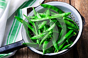 Fresh, organic green beans in a vintage colander