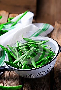 Fresh, organic green beans in a vintage colander