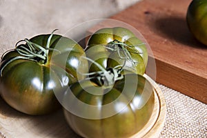 Fresh and organic green tomatoes on a wooden table
