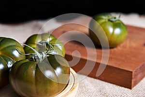 Fresh and organic green tomatoes on a wooden table