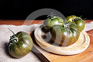 Fresh and organic green tomatoes on a wooden table