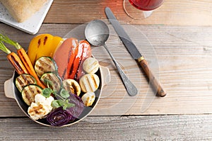 Fresh organic grilled vegetables bell pepper,mushrooms,broccoli,cauliflower,carrots seasoned with herbs on a round plate