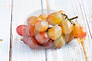 Fresh organic group of sweet juicy and healthy grapes fruit on white wooden board background